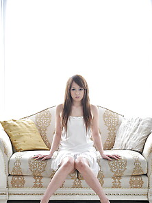 Beautiful Girl From Japan In White Dress Prefers To Sit On White